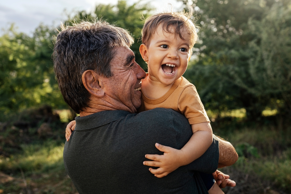 Father and child smiling with healthy teeth after Children's dentistry visit in Rapid City
