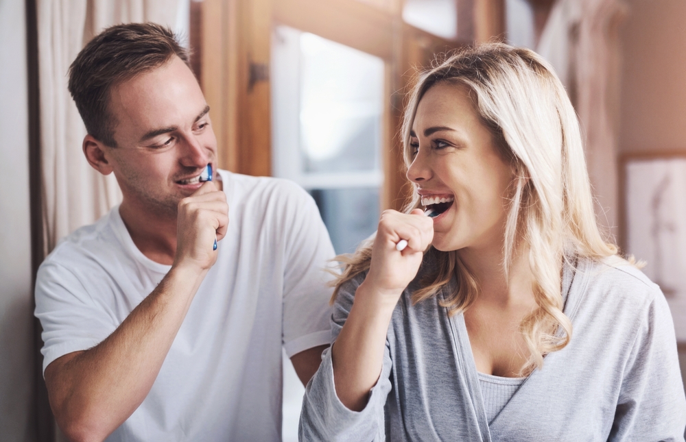 Couple brushing teeth together promoting good oral hygiene habits in Rapid City SD