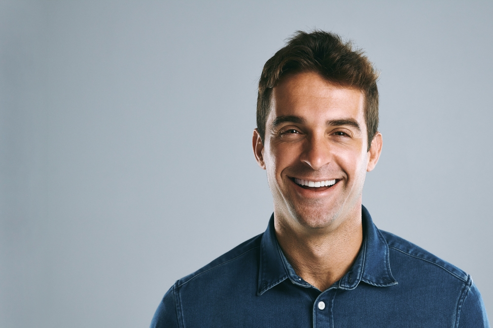 Smiling man with short dark hair in a denim shirt