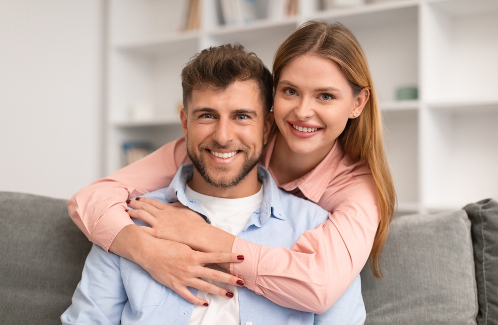 Smiling couple embracing on a sofa
