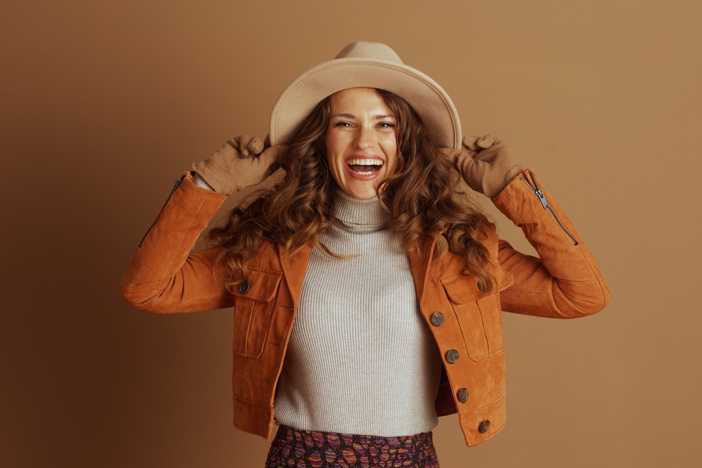 Laughing woman in a hat and orange jacket